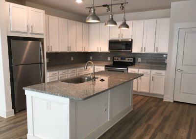 Acadia White Cabinets Finished Kitchen and Island Dark Gray Marbled Counter Tops