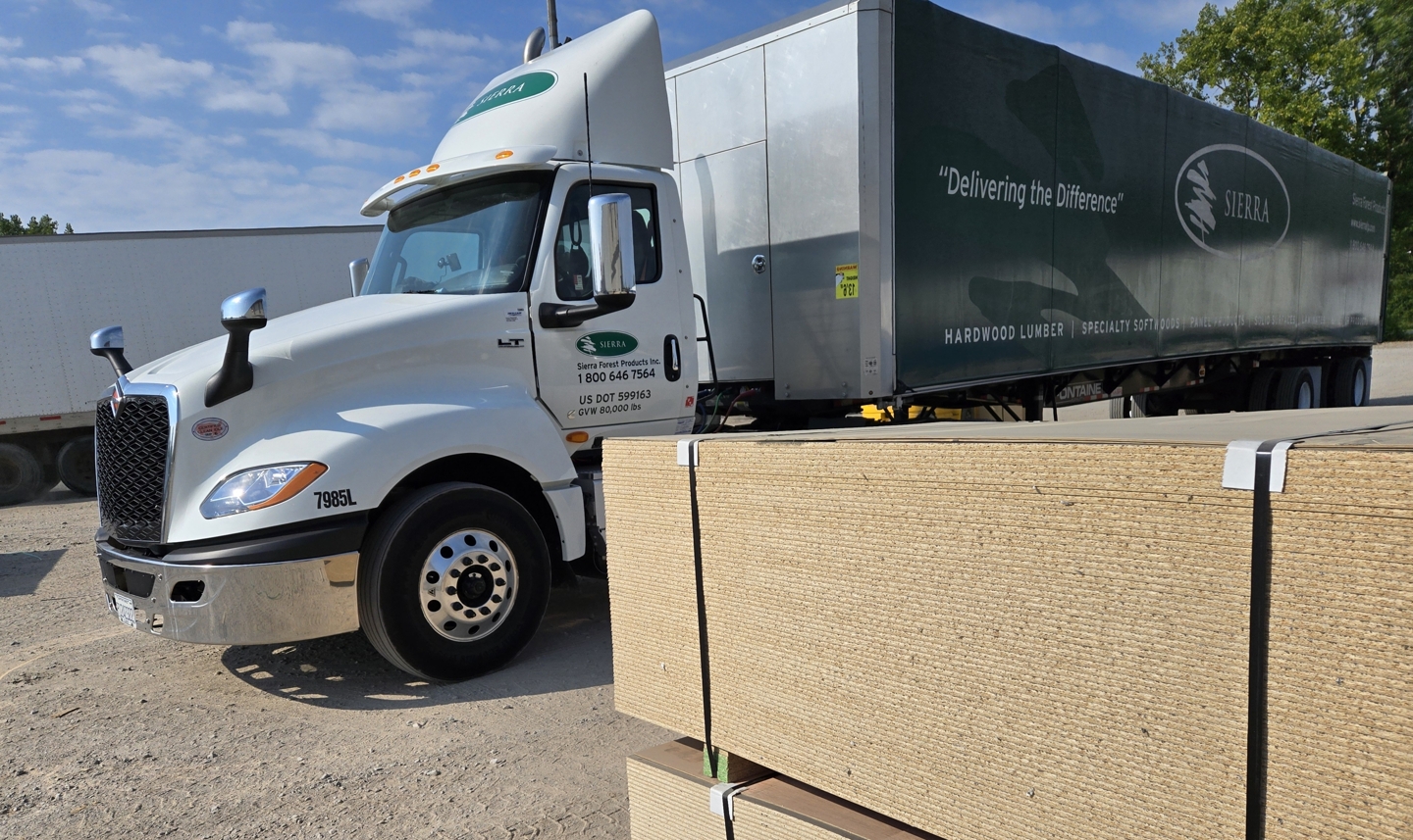 Sierra Truck side view Delivering Materials to Saco Green and White Semi Truck